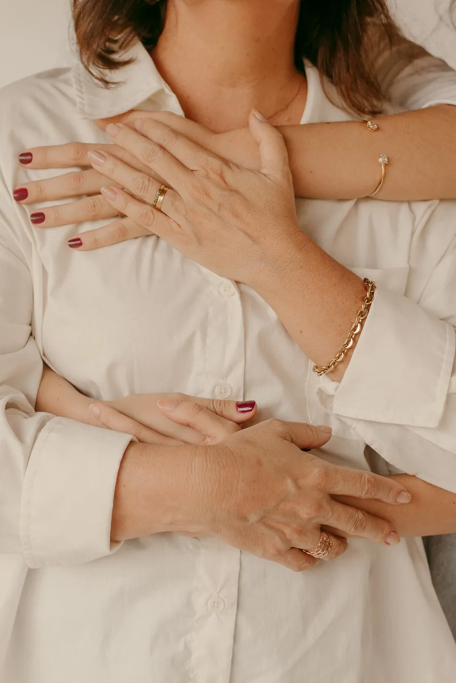 Mãos de mãe e filha entrelaçadas