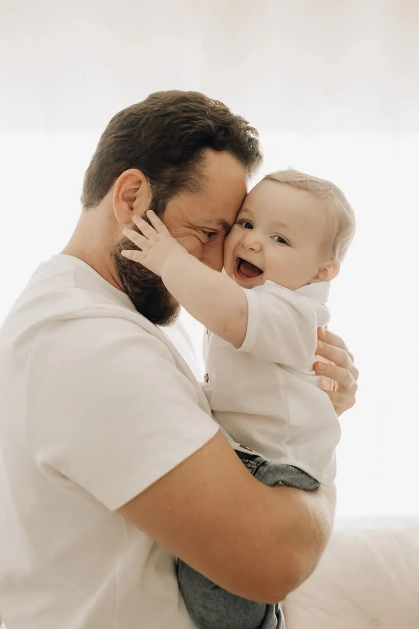 Pai com o bebê no colo, rindo