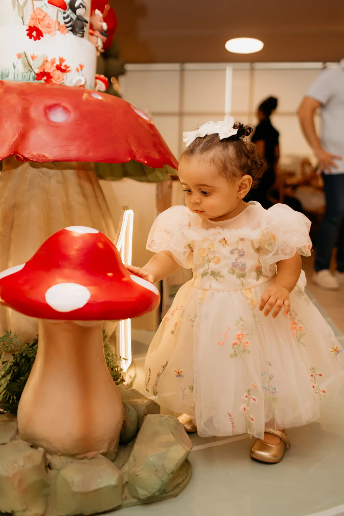 Aniversariante de um ano entre os cogumelos da decoração
