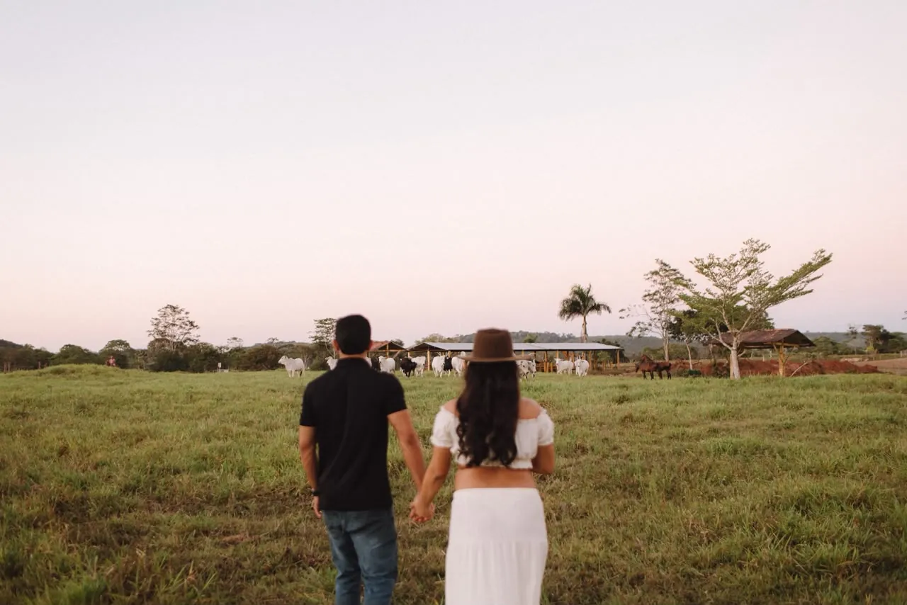 Casal caminhando no campo ao entardecer