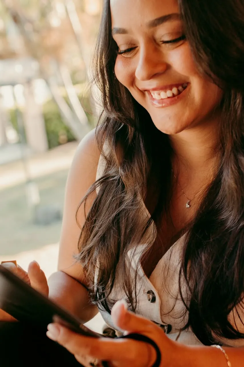 Júlia Marins sorrindo perto da janela
